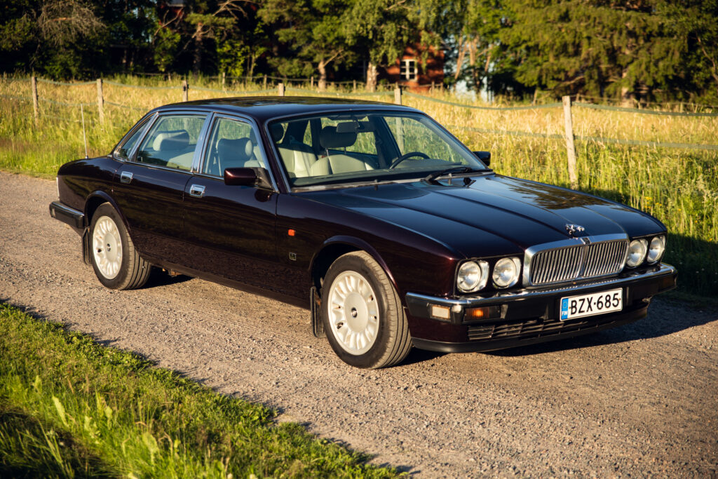 Classic dark luxury sedan on country road