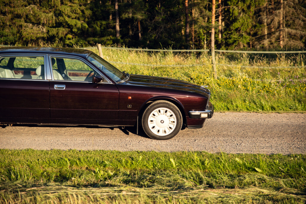 Vintage maroon sedan parked on rural roadside