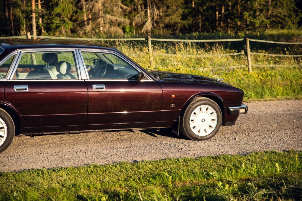 Vintage maroon sedan parked on rural roadside