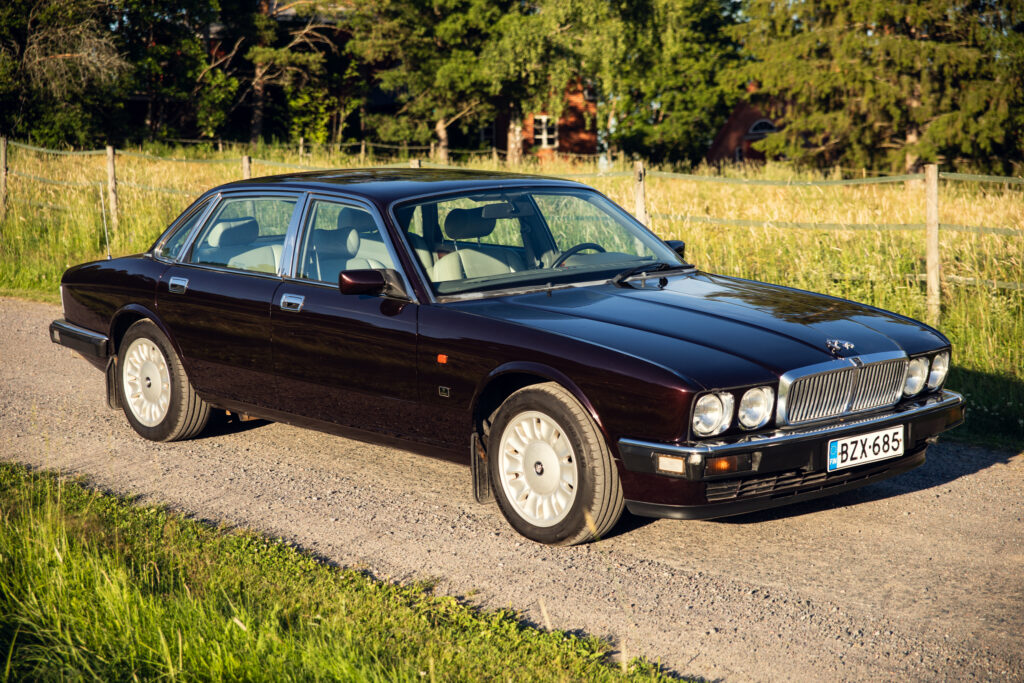 Classic Jaguar sedan parked on rural gravel road