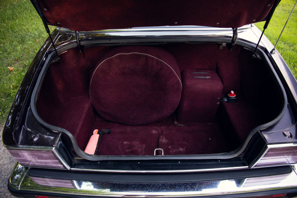 Open car trunk with burgundy carpet interior