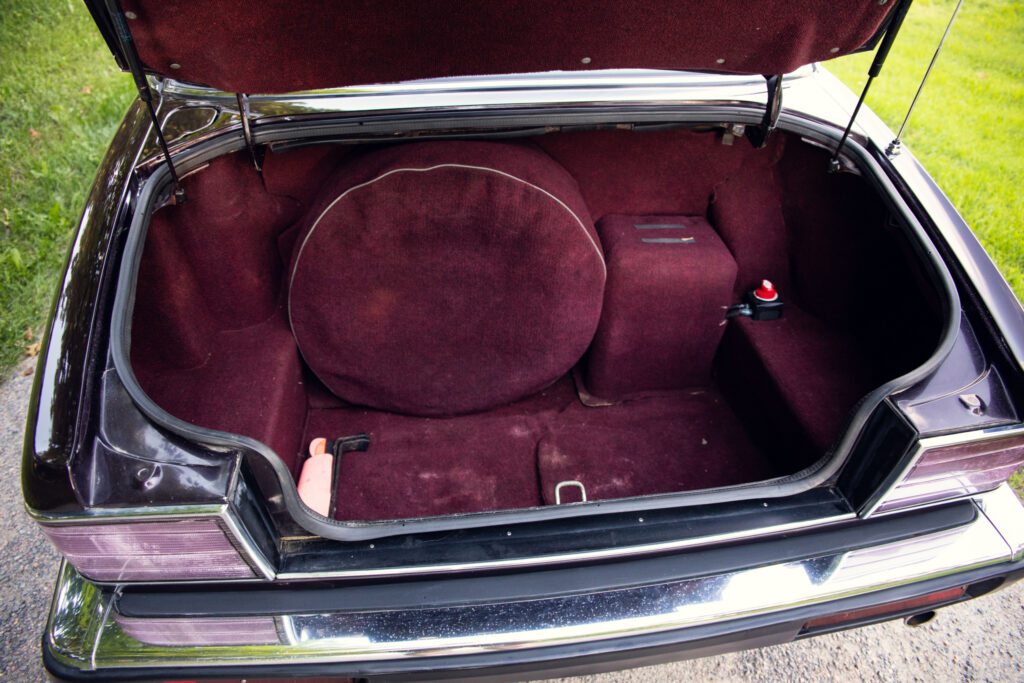 Open car trunk with burgundy carpet interior