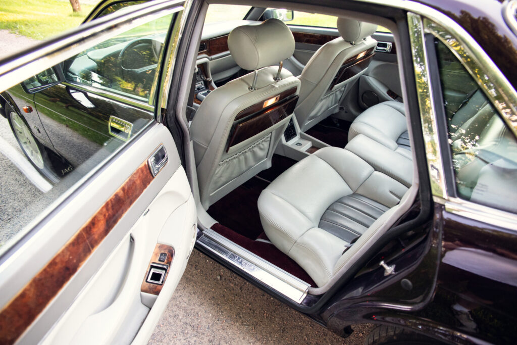 Luxury car rear interior with cream leather seats