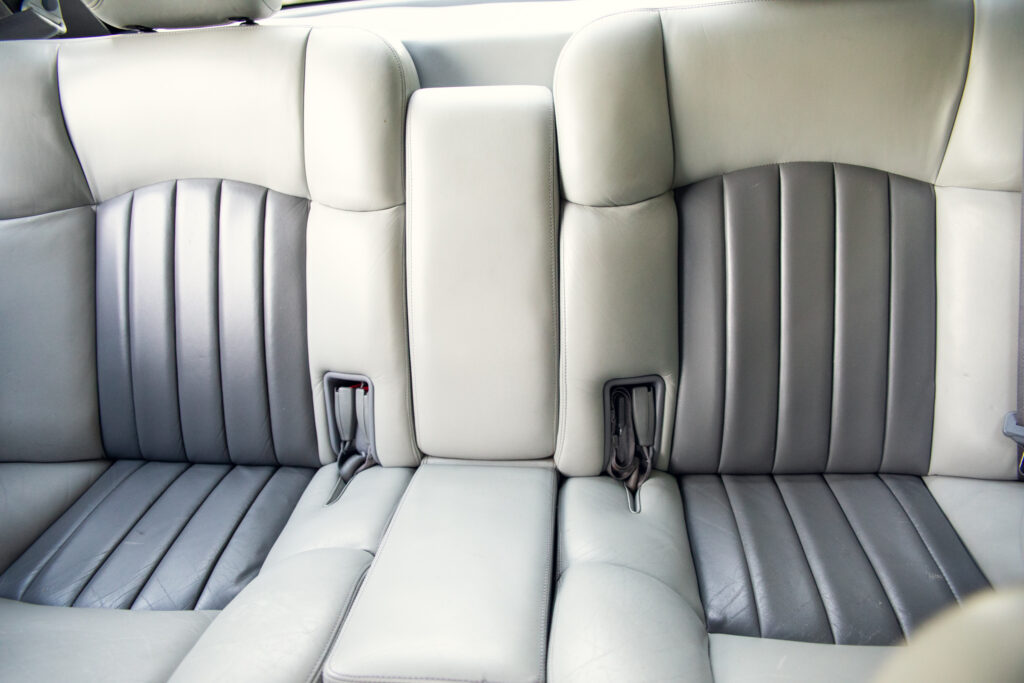 Light gray leather car back seat with seatbelts