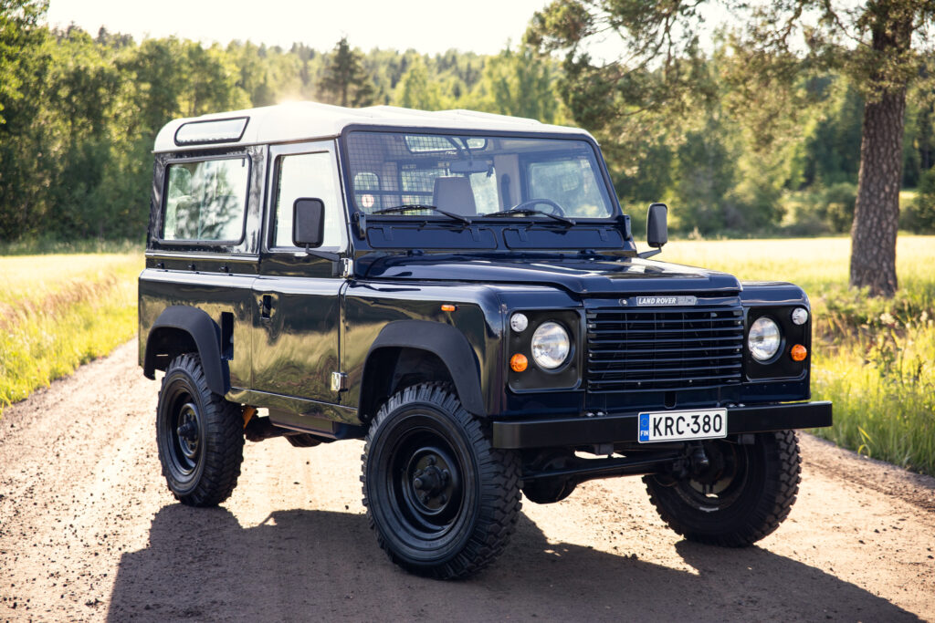 Black Land Rover Defender on rural dirt road