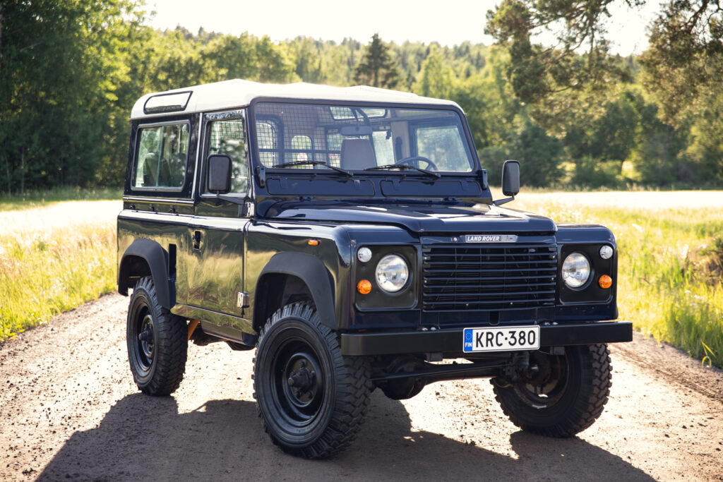 Black Land Rover Defender on rural dirt road