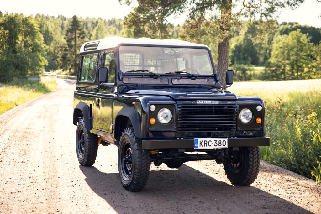 Black Land Rover Defender on rural dirt road