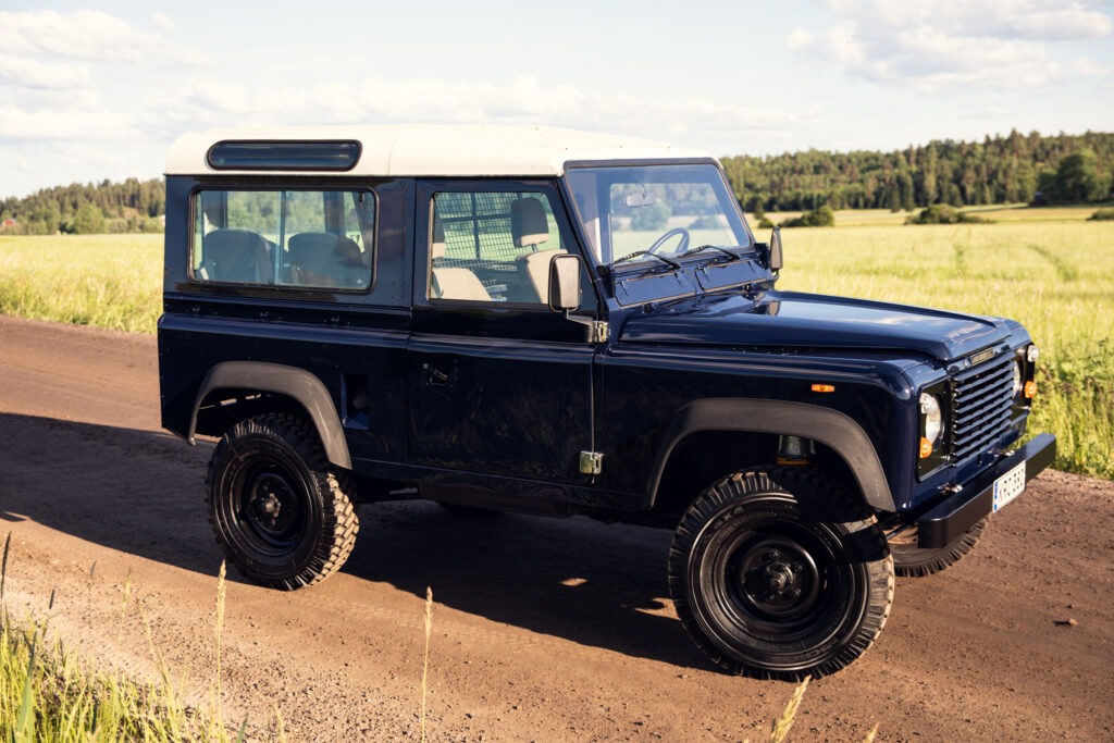 Classic dark blue Land Rover on rural road
