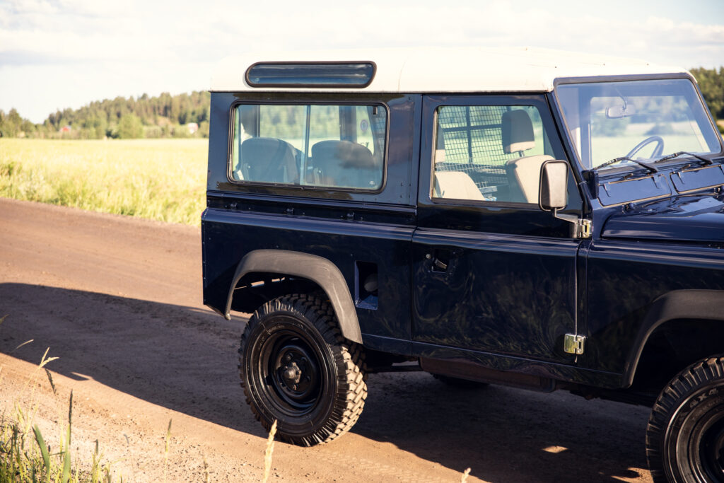 Classic blue Land Rover on country dirt road