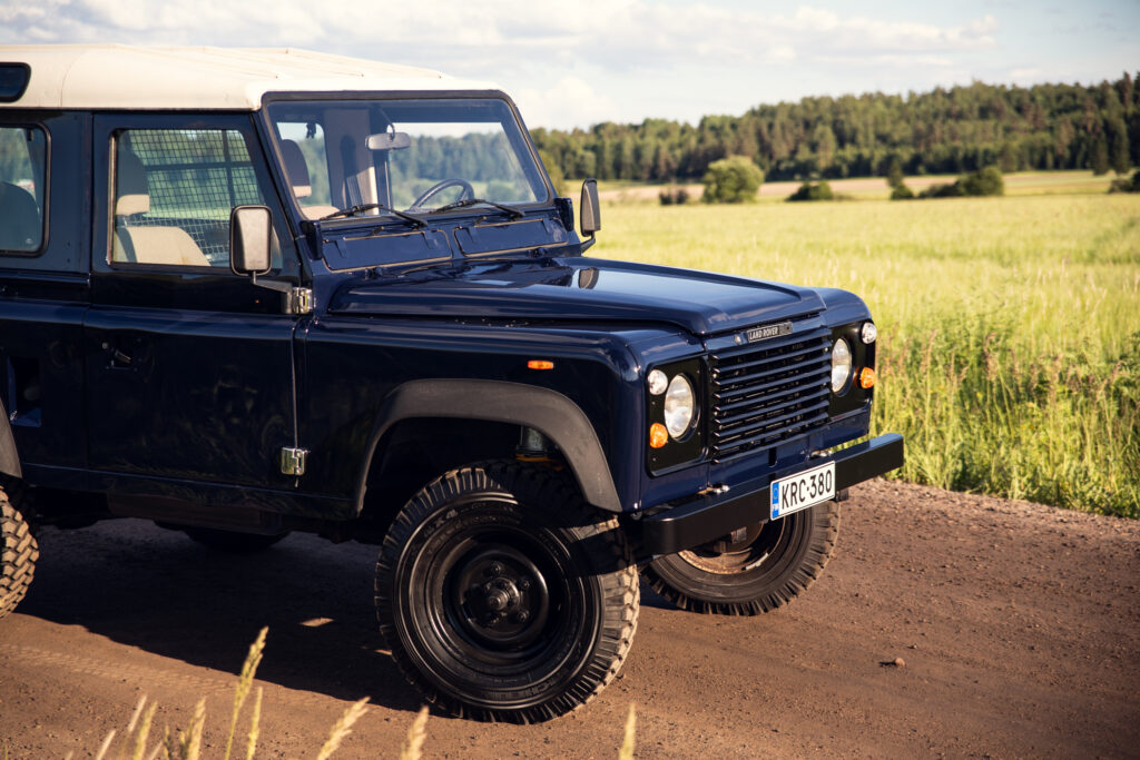 Blue Land Rover Defender on rural dirt road