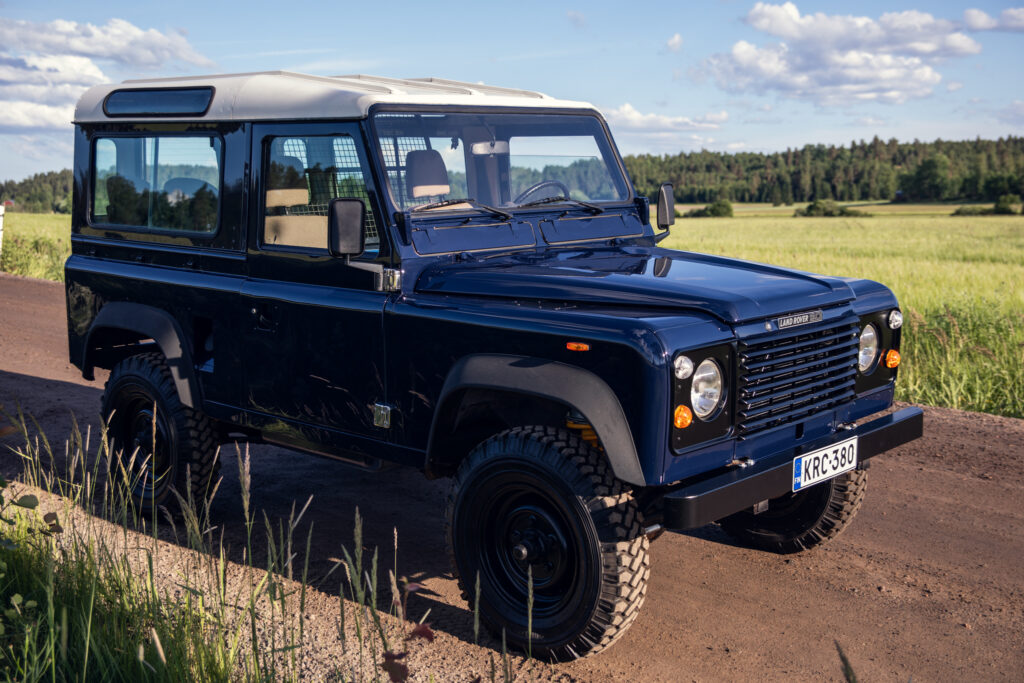 Blue Land Rover Defender on rural dirt road