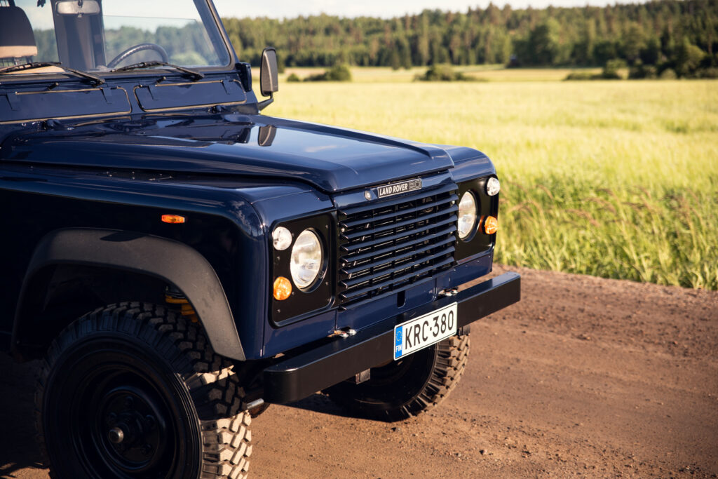 Blue Land Rover Defender on rural dirt road