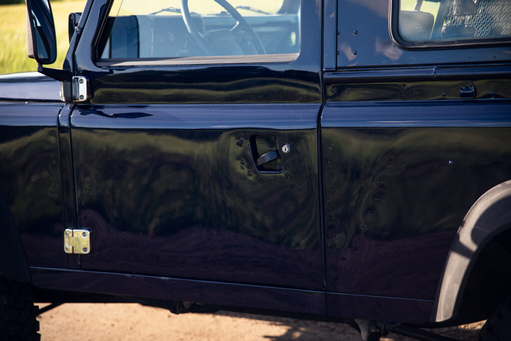 Black SUV door with multiple bullet holes