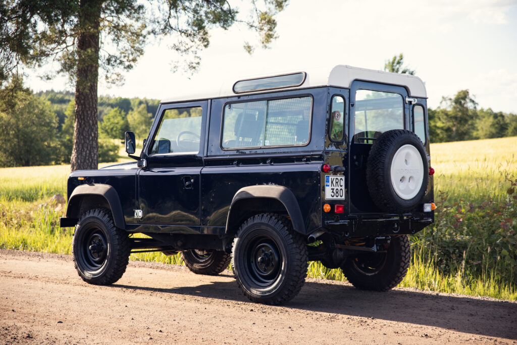Classic black Land Rover on country road