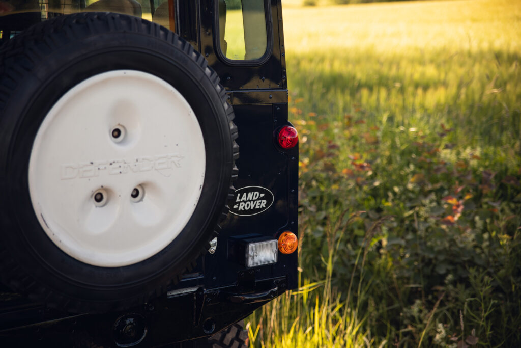 Rear of Land Rover Defender in grassy field
