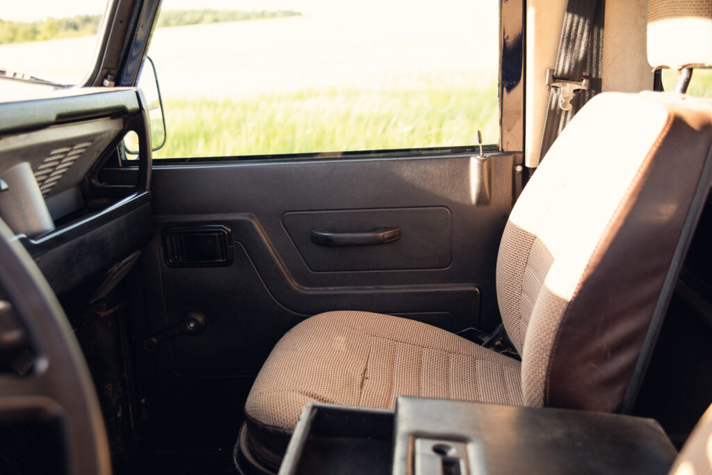 Passenger seat inside vintage SUV with countryside view