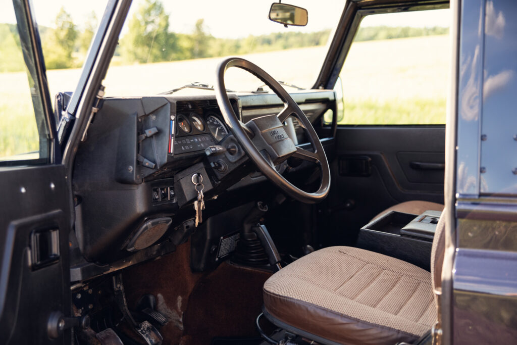Vintage Land Rover interior with steering wheel and dashboard