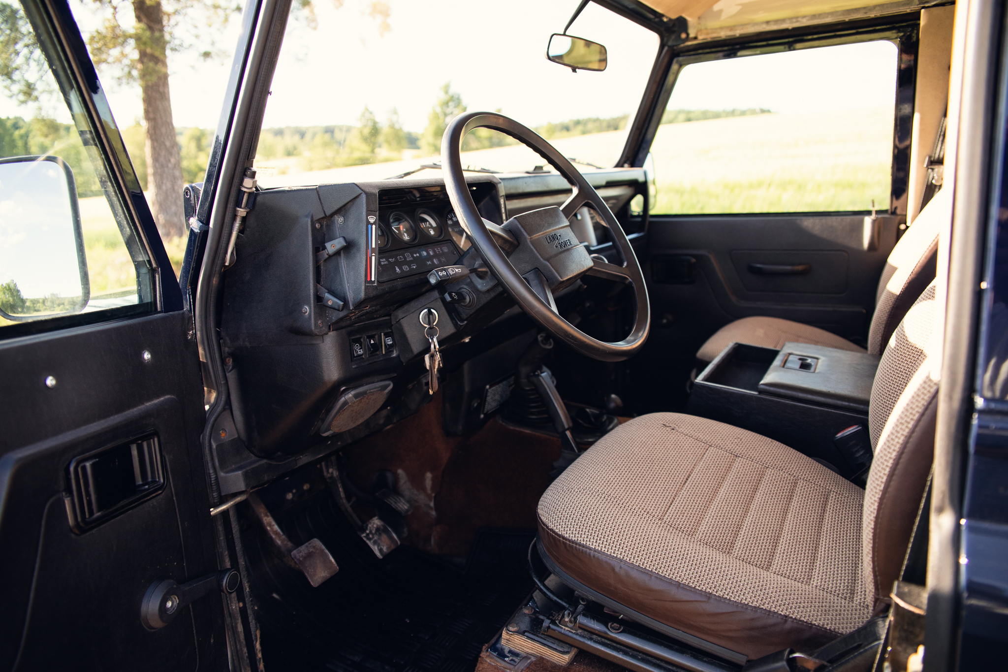 Vintage Land Rover interior with steering wheel and seat