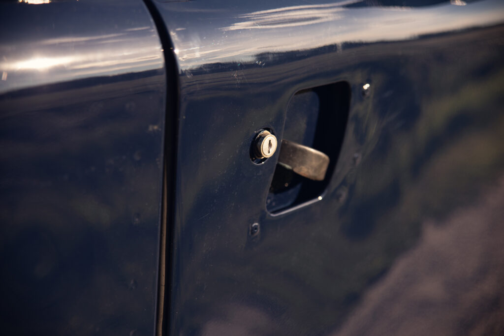 Close-up of blue car door handle and lock