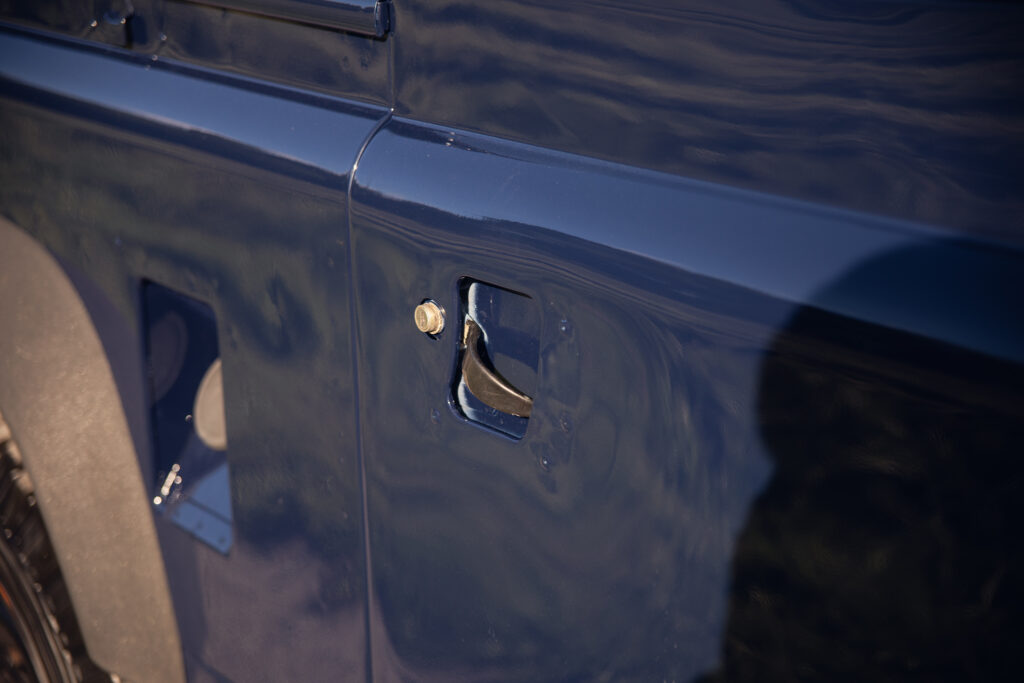 Close-up of blue vehicle door handle and lock