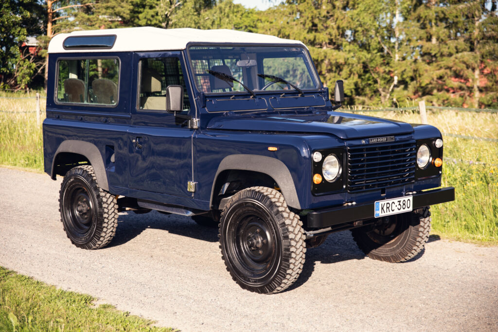 Classic blue Land Rover Defender on rural road