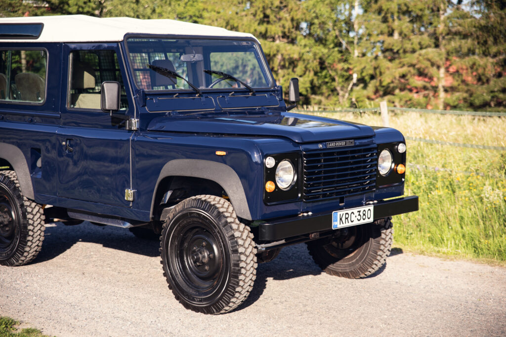 Blue classic Land Rover Defender parked outdoors