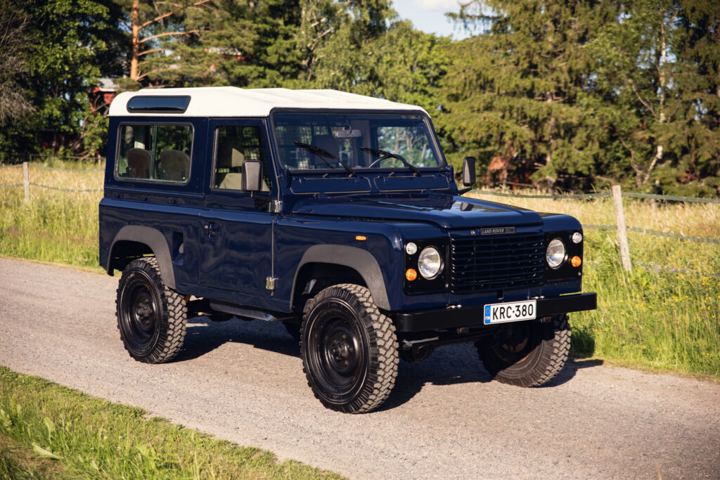 Classic blue Land Rover Defender on rural road