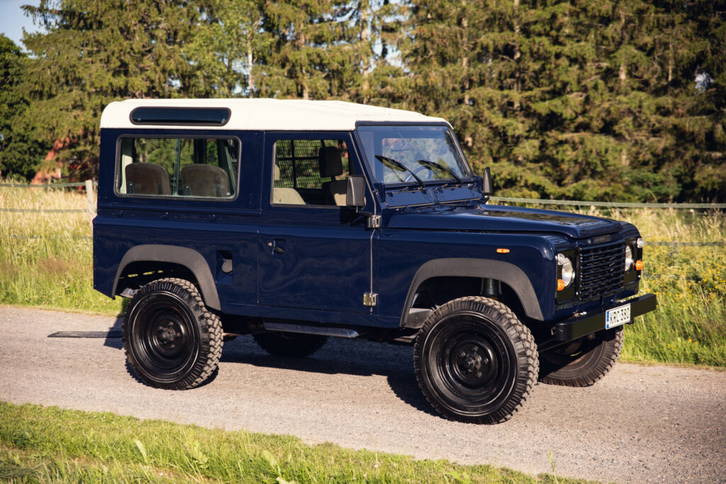 Classic blue Land Rover Defender on rural road