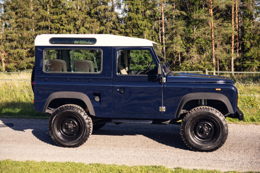 Blue Land Rover Defender on rural road