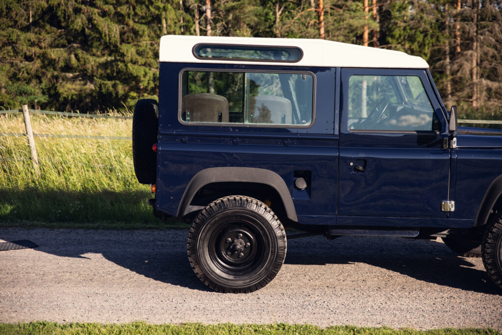 Blue vintage SUV parked on rural road