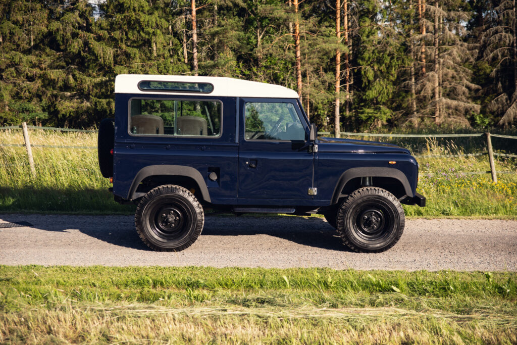 Classic blue Land Rover Defender on country road