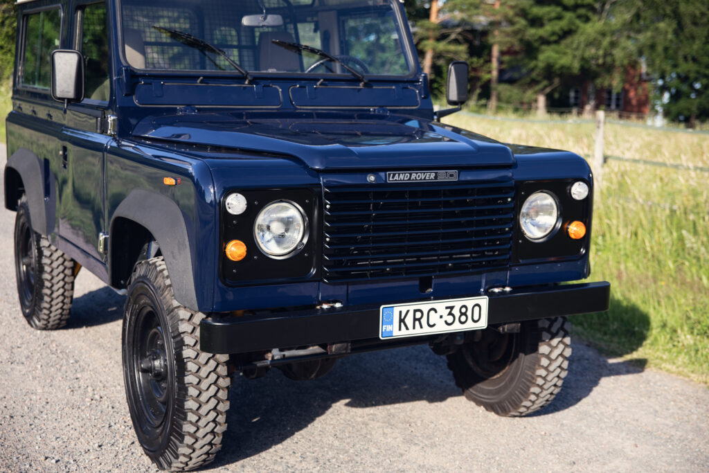 Dark blue Land Rover Defender on gravel road