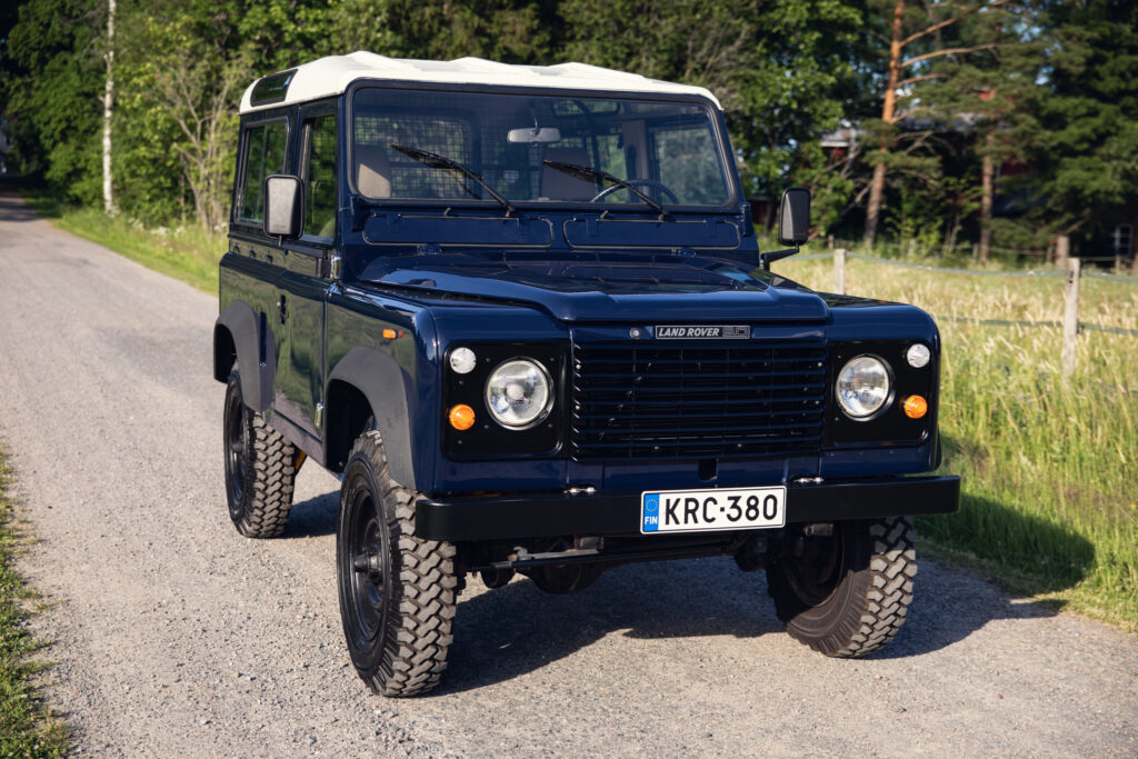 Classic blue Land Rover Defender on rural road