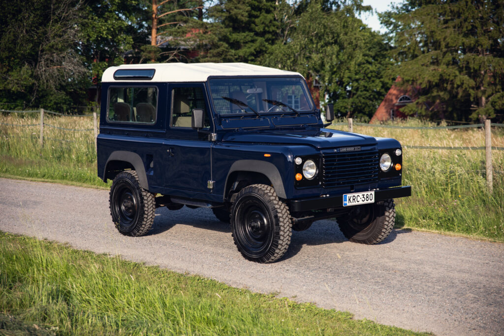 Classic blue Land Rover 90 V8 on rural road