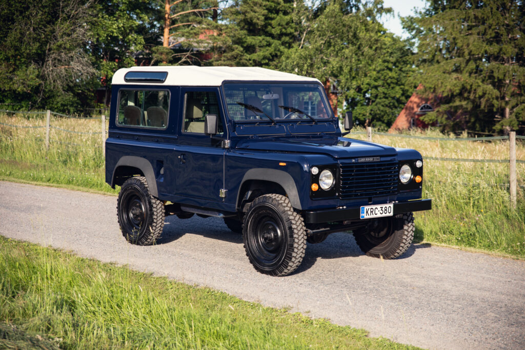 Classic blue Land Rover Defender on rural road