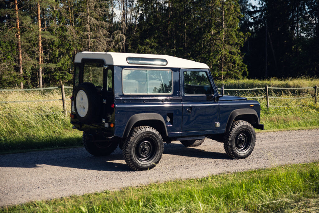 Classic blue Land Rover on rural gravel road