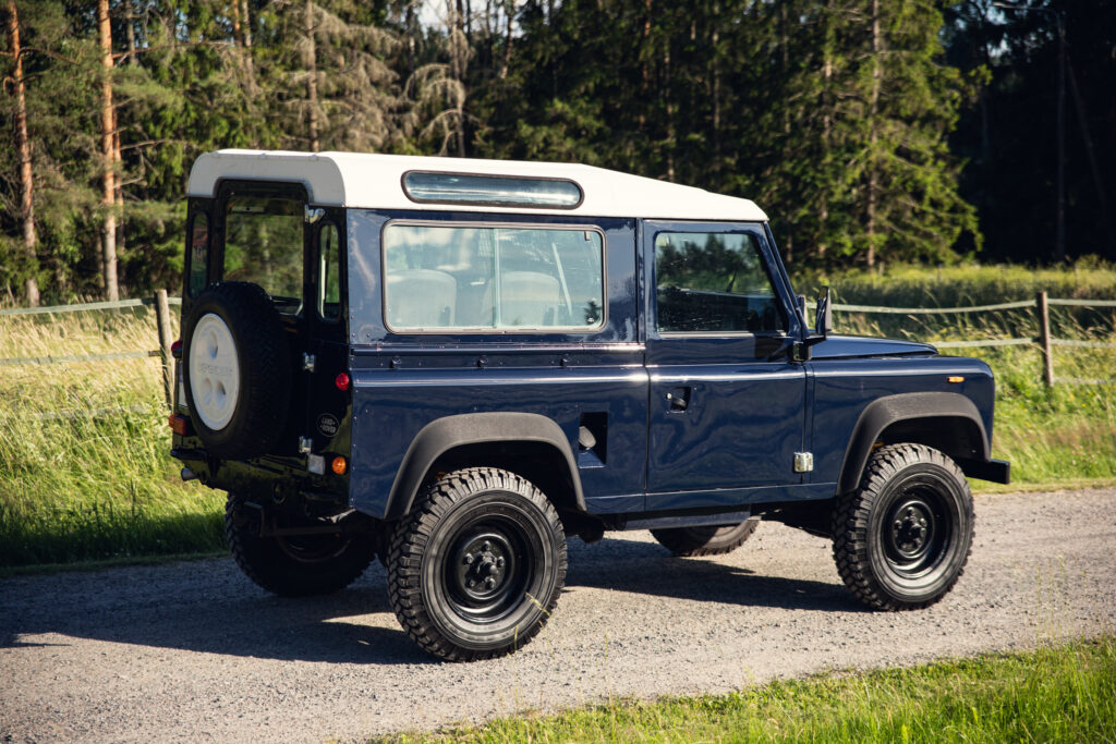 Classic blue Land Rover Defender on gravel road