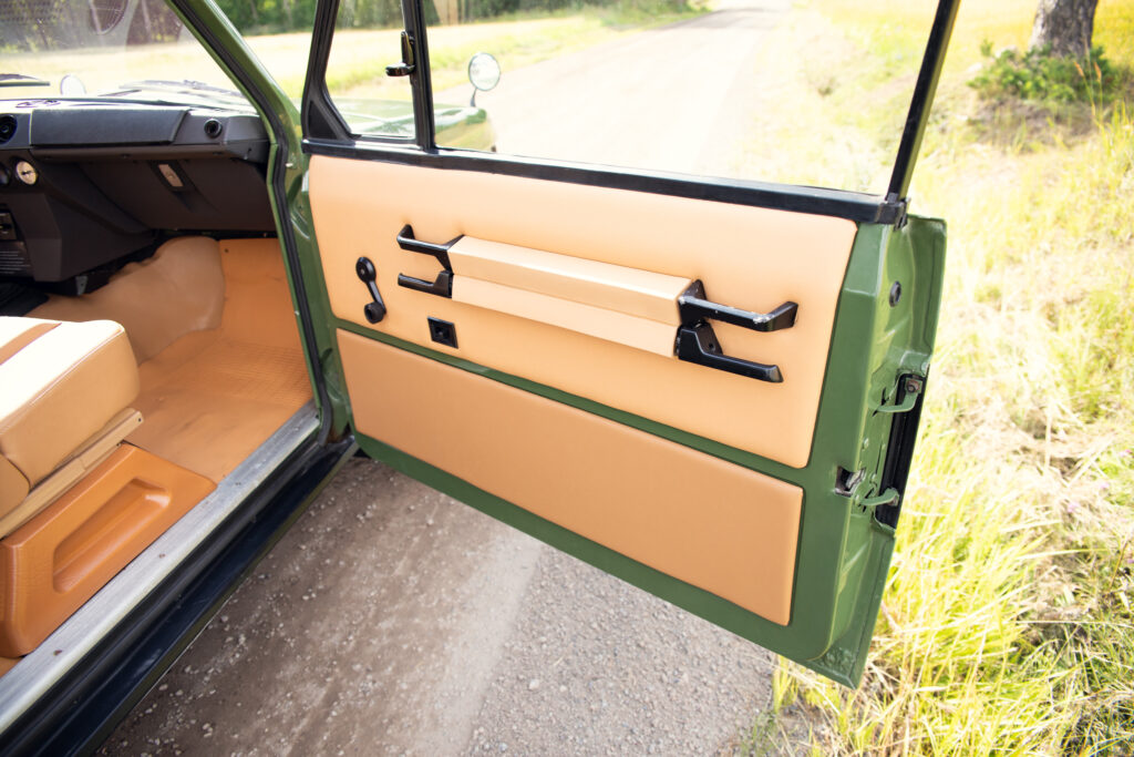 Open vintage car door with tan interior panel