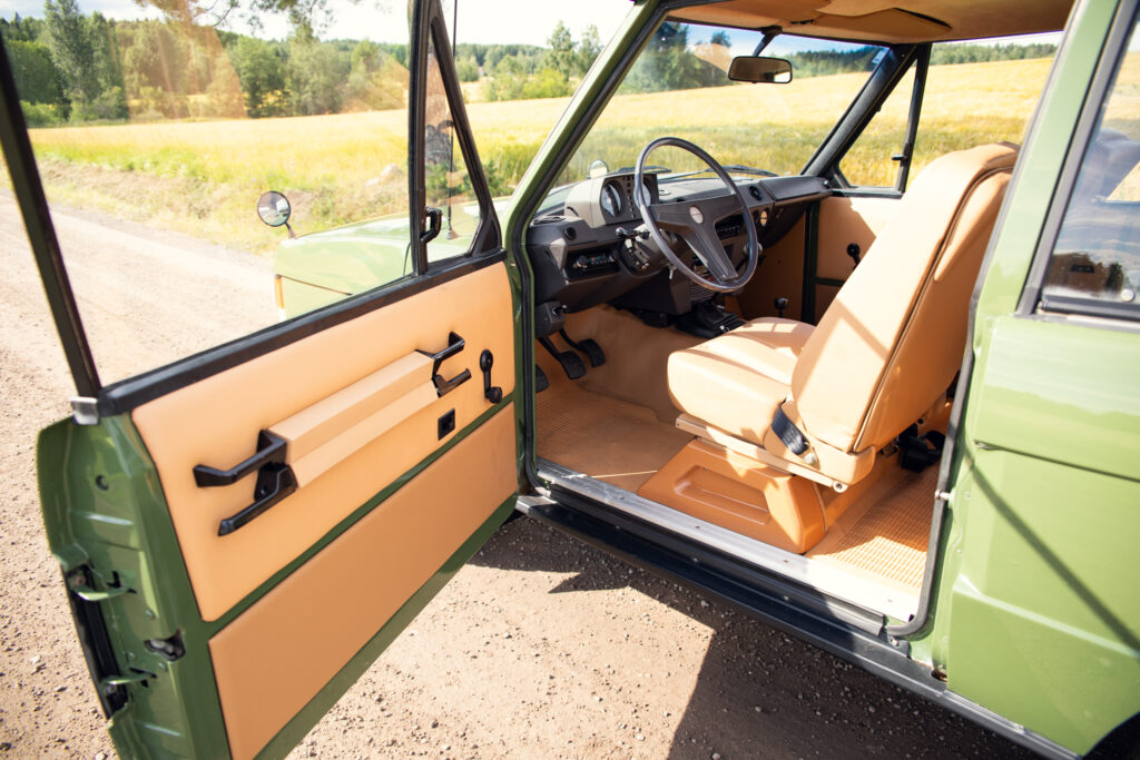 Vintage car interior with tan seats and open door