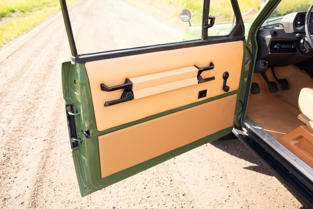 Open vintage green car door with tan panel