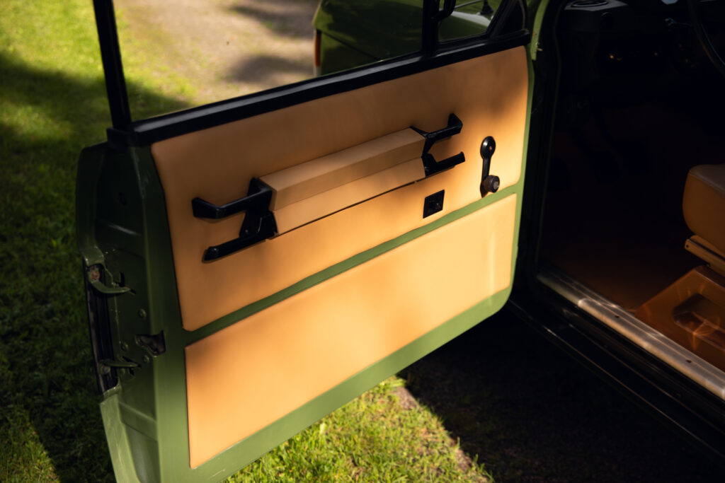 Open vintage car door with tan interior panel