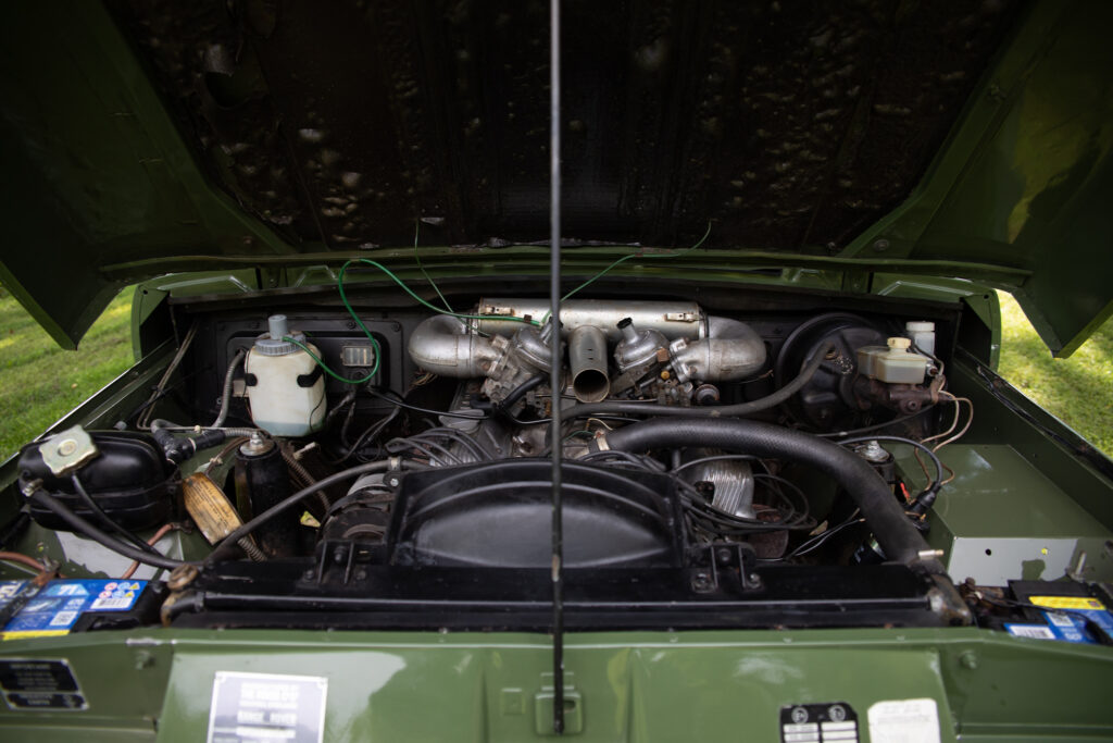 Open hood showing classic green SUV engine bay