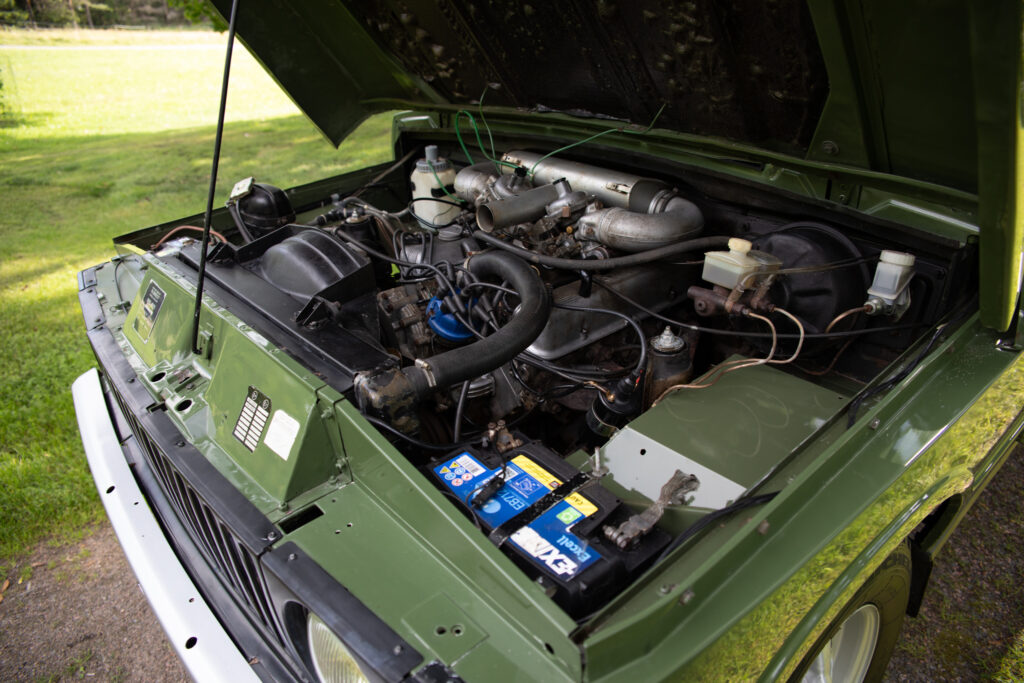 Open hood of green vintage SUV engine