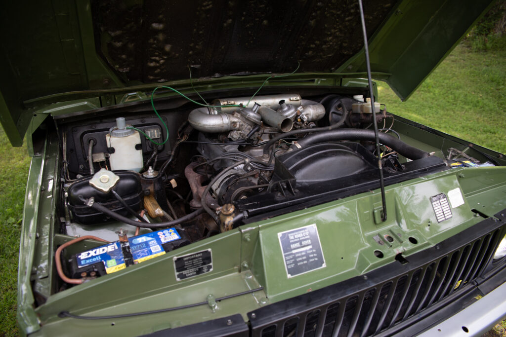 Open hood revealing vintage vehicle engine bay